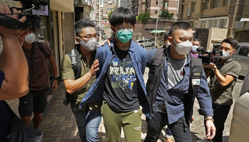 En student ved Hong Kong University (med grønn maske) blir eskortert av politiet etter arrestasjon onsdag 18. august. Til sammen fire studentledere er arrestert denne dagen. En student ved Hong Kong University (med grønn maske) blir eskortert av politiet etter arrestasjon onsdag 18. august. Til sammen fire studentledere er arrestert denne dagen.