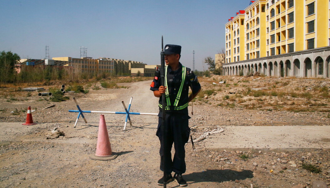 En kinesisk politimann holder vakt ved det sim offisielt heter et ferie- og opplæringssenter i Yining i Xinjiang-provinsen. Bildet er tatt 4. september, 2018. Tvangsarbeidsleire for uigurer eksisterer ikke her, mente nederlandske forskere ved et menneskerettssenter finansiert fra Kina.