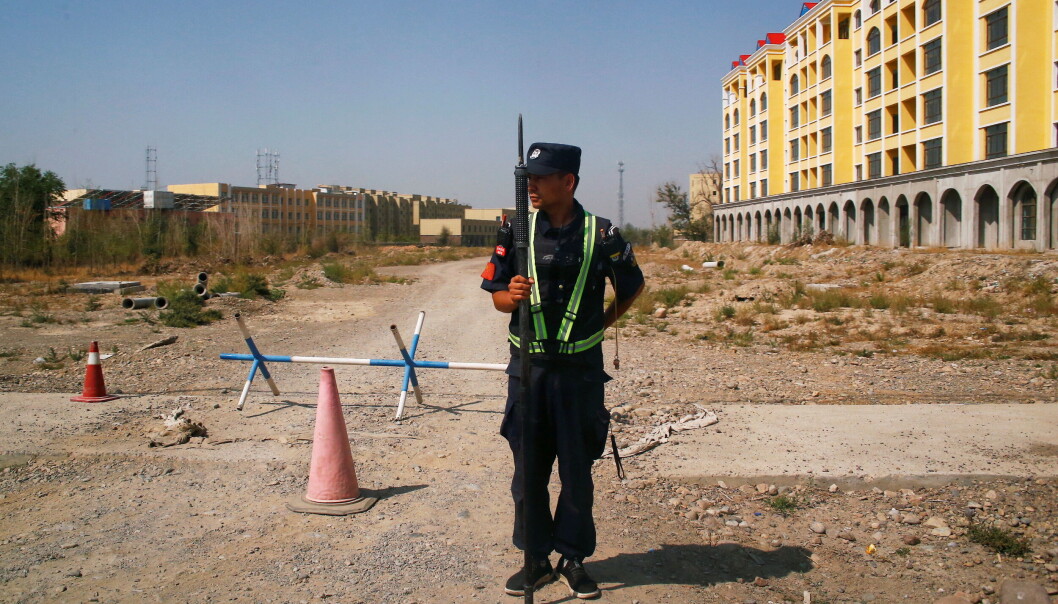 En kinesisk politimann holder vakt ved det sim offisielt heter et ferie- og opplæringssenter i Yining i Xinjiang-provinsen. Bildet er tatt 4. september, 2018. Tvangsarbeidsleire for uigurer eksisterer ikke her, mente nederlandske forskere ved et menneskerettssenter finansiert fra Kina. En kinesisk politimann holder vakt ved det sim offisielt heter et ferie- og opplæringssenter i Yining i Xinjiang-provinsen. Bildet er tatt 4. september, 2018. Tvangsarbeidsleire for uigurer eksisterer ikke her, mente nederlandske forskere ved et menneskerettssenter finansiert fra Kina.