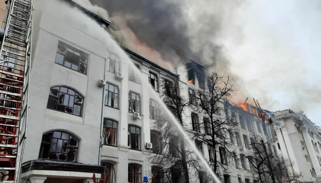 Brannmenn forsøker å slukke etter at universitetsbygninger ble truffet av raketter.