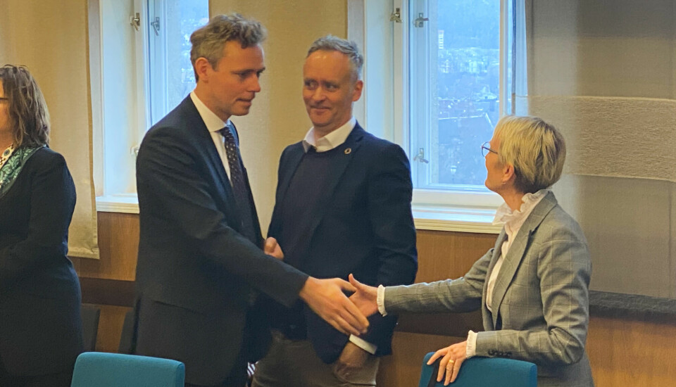 Statråd og rektor tar hverandre i hånda mens Statsbyggs Marius Tunstad følger med.
