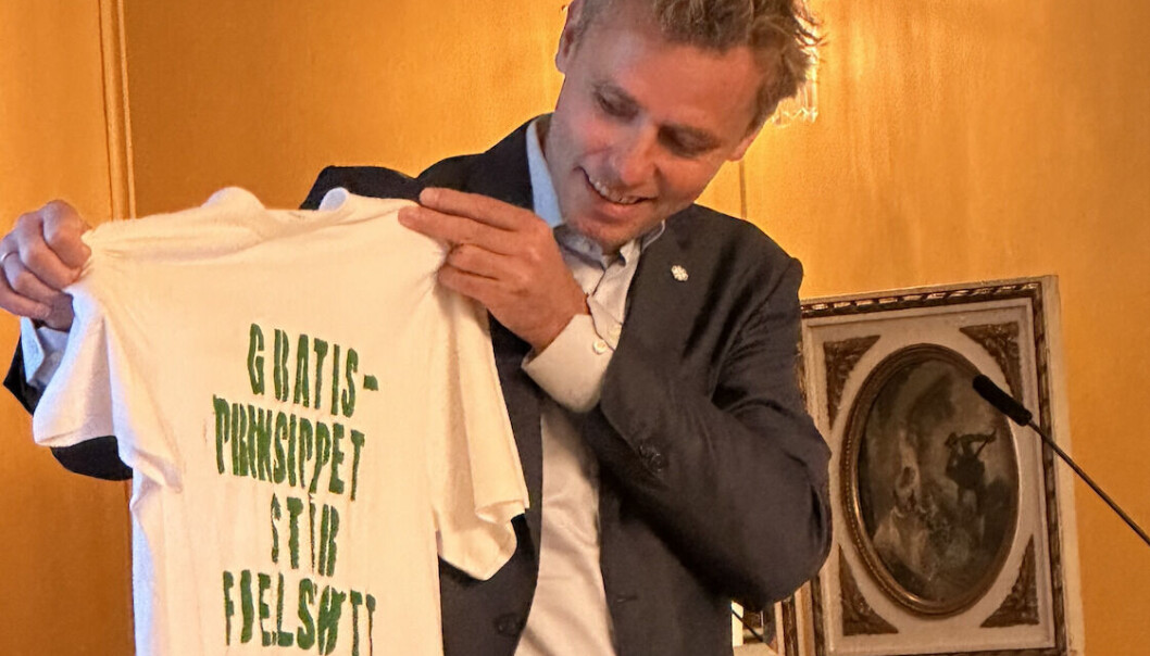 Ministeren hadde fått tips om at han ville bli møtt med T-skjortekledde studenter, og fikk sin egen T-skjorte lagd for anledningen. Selv var han godt fornøyd med resultatet. Ministeren hadde fått tips om at han ville bli møtt med T-skjortekledde studenter, og fikk sin egen T-skjorte lagd for anledningen. Selv var han godt fornøyd med resultatet.