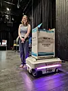 Stor prototype på en plattform i et mørkt lokale, med en person stående ved siden av.