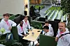 Seks menn sitter rundt et bord inne