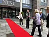 Flere personer ankommer NTNU over en rød løper utenfor universitetsbygningen.